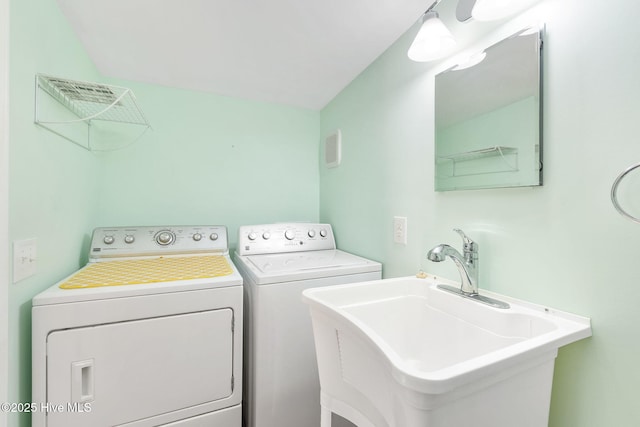 washroom featuring a sink, laundry area, and washer and dryer