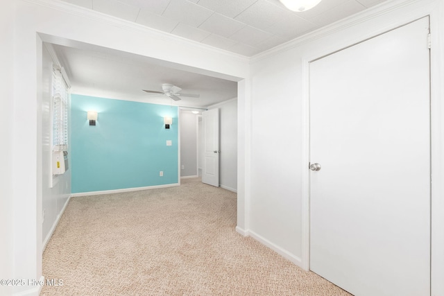 carpeted empty room featuring baseboards, ceiling fan, and ornamental molding
