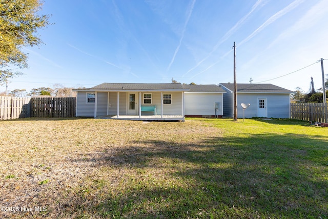 back of house featuring a fenced backyard and a yard