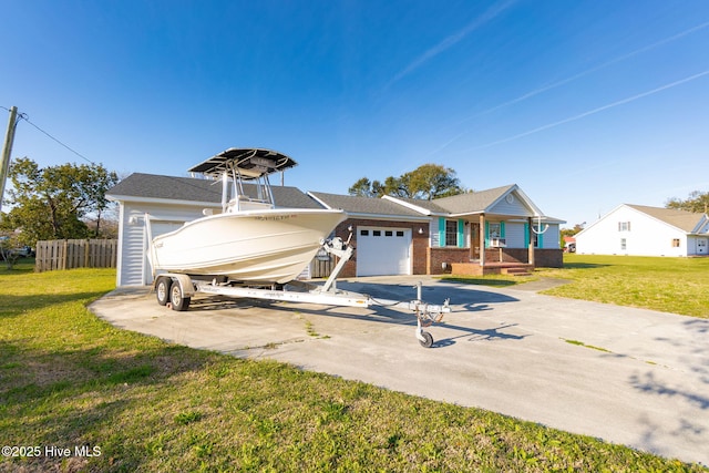 single story home featuring brick siding, a front yard, driveway, and an attached garage