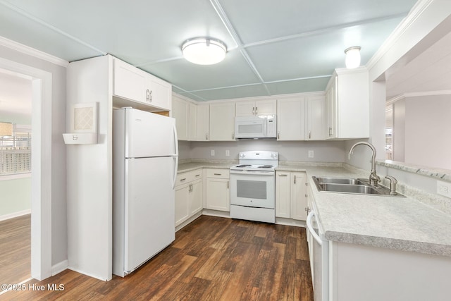 kitchen with light countertops, white appliances, dark wood-type flooring, a sink, and white cabinets