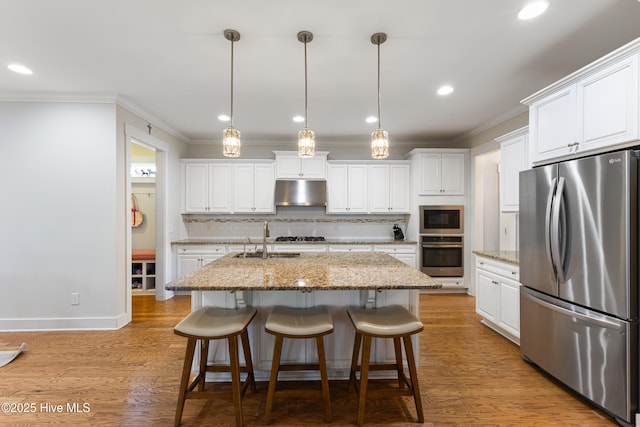 kitchen featuring under cabinet range hood, tasteful backsplash, crown molding, and stainless steel appliances