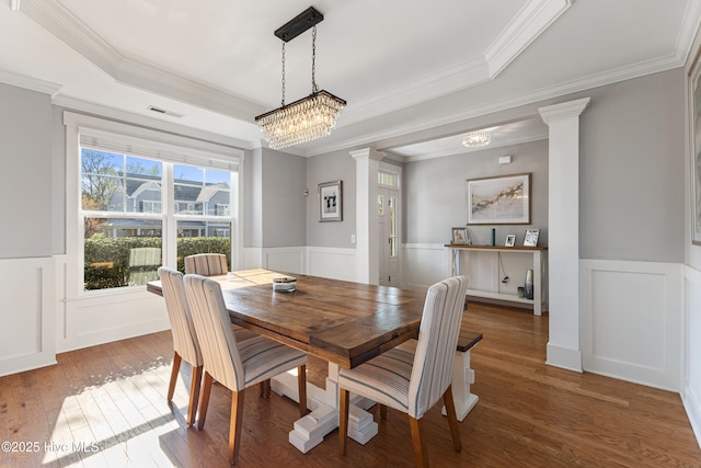 1025 Anchors Bend Way, Wilmington, NC 28411 - dining space with ornate columns, a raised ceiling, a wainscoted wall, hardwood / wood-style floors, and crown molding