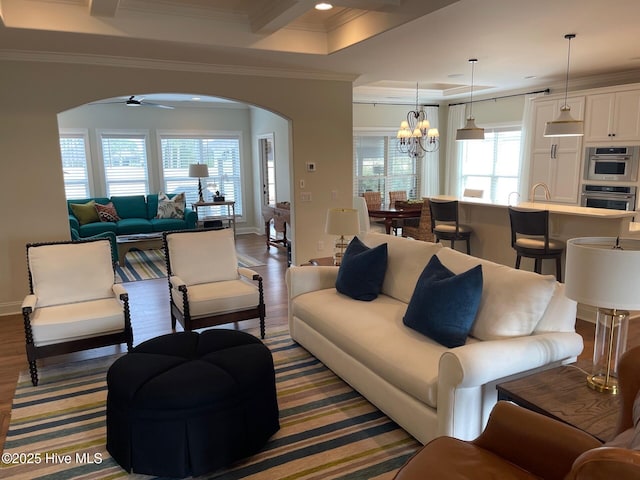 1325 Grandiflora Dr, Leland, NC 28451 - living room featuring ornamental molding, arched walkways, and ceiling fan with notable chandelier