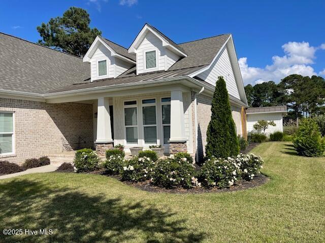 1325 Grandiflora Dr, Leland, NC 28451 - view of front of house featuring a front yard and brick siding
