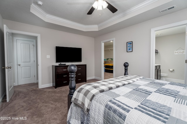 carpeted bedroom featuring a tray ceiling, crown molding, a spacious closet, baseboards, and visible vents