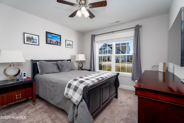 bedroom featuring light carpet, baseboards, visible vents, and a ceiling fan