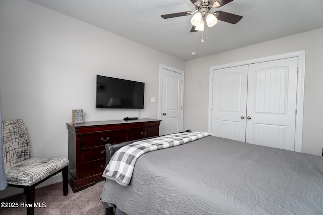 carpeted bedroom with a closet, ceiling fan, and a textured ceiling