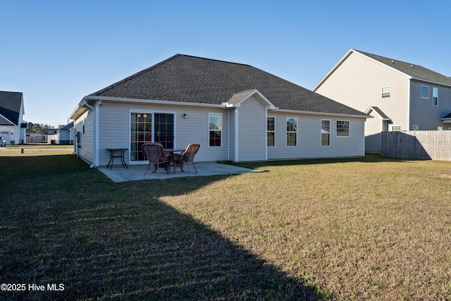 back of house with a yard, roof with shingles, fence, and a patio