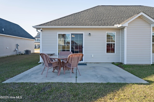 rear view of house with central AC, a shingled roof, a yard, and a patio