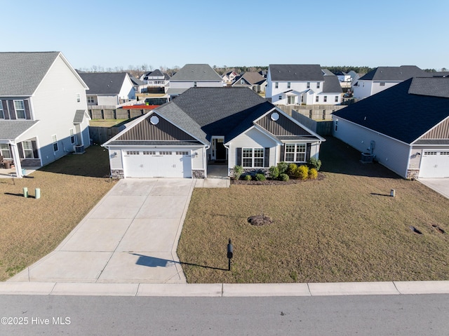 view of front of home featuring a garage, concrete driveway, a front yard, and a residential view