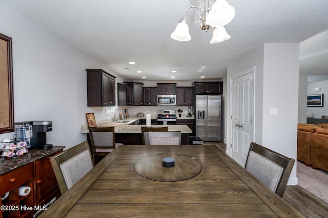 dining room with a textured ceiling, a chandelier, and recessed lighting