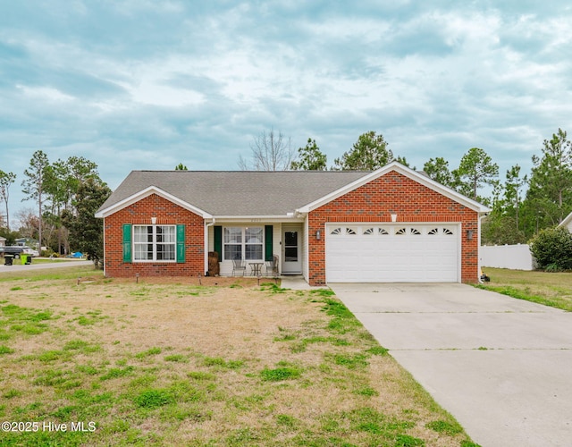 ranch-style house featuring driveway, fence, an attached garage, brick siding, and a front lawn