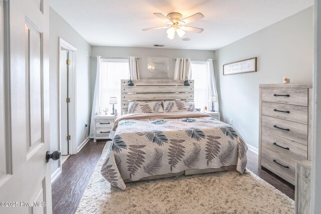 bedroom featuring baseboards, visible vents, wood finished floors, and ceiling fan