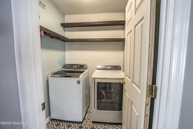 laundry room with a textured ceiling and independent washer and dryer