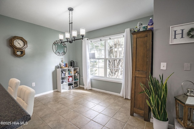 dining area with light tile patterned flooring, baseboards, and a chandelier