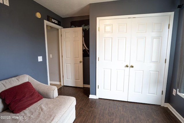 sitting room featuring baseboards and dark wood finished floors