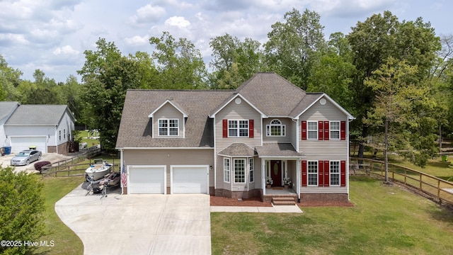 traditional home featuring fence, a front lawn, driveway, and roof with shingles