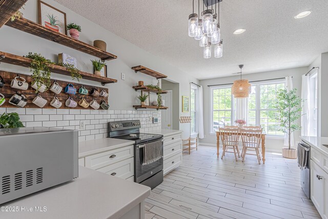 kitchen featuring open shelves, a textured ceiling, and electric range
