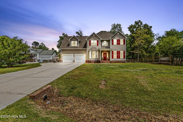 traditional-style home with a shingled roof, concrete driveway, and a front lawn