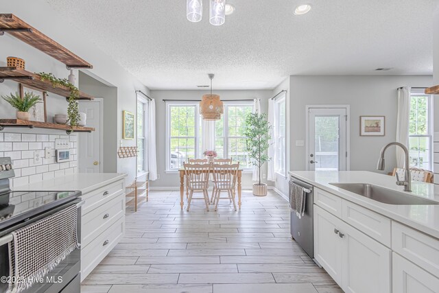 kitchen featuring light countertops, a sink, baseboards, and stainless steel appliances