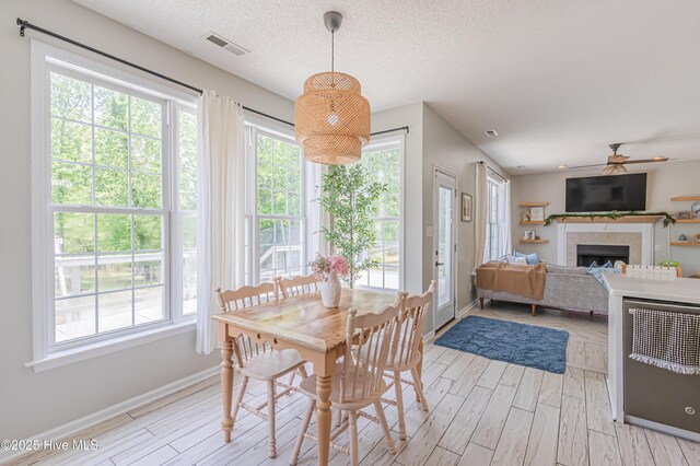 dining room featuring ceiling fan, visible vents, baseboards, and light wood-style floors