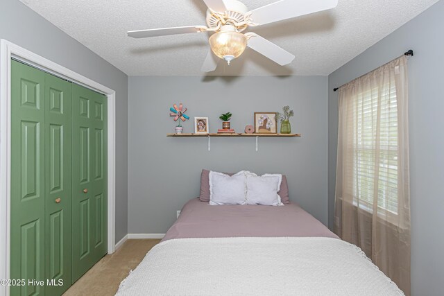 carpeted bedroom with a textured ceiling, multiple windows, and a closet