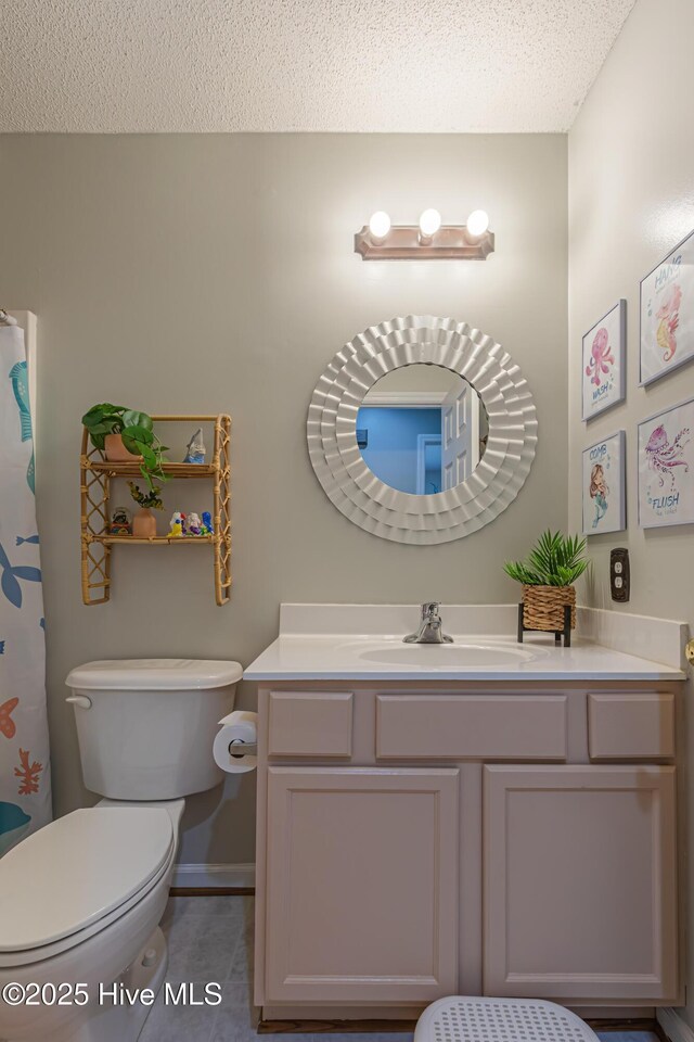 full bathroom with vanity, a textured ceiling, baseboards, and toilet