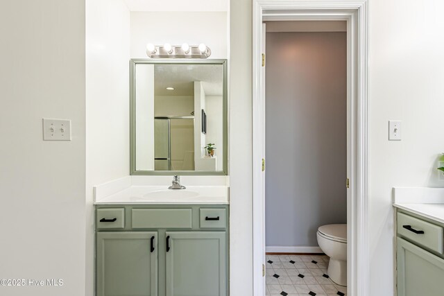 full bath featuring tile patterned flooring, a shower stall, vanity, baseboards, and toilet