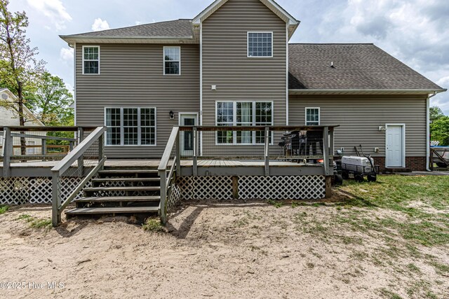 rear view of property featuring a wooden deck and roof with shingles