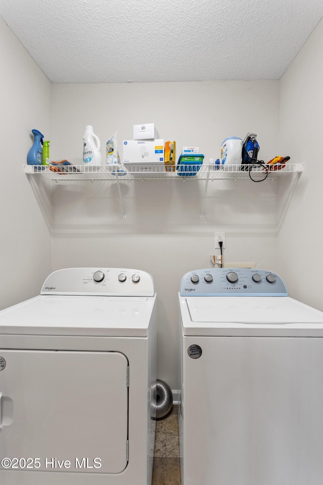 laundry area featuring independent washer and dryer, laundry area, and a textured ceiling