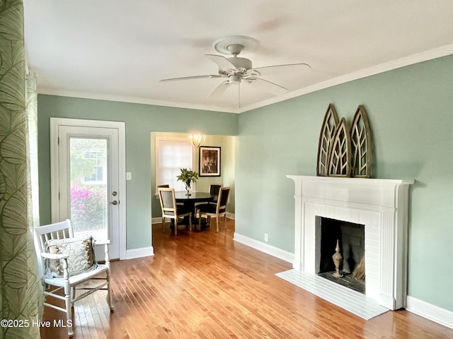 102 N 25th St, Wilmington, NC 28405 - living area featuring light wood-type flooring, ceiling fan, crown molding, a brick fireplace, and baseboards