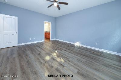 spare room featuring a ceiling fan, baseboards, and wood finished floors