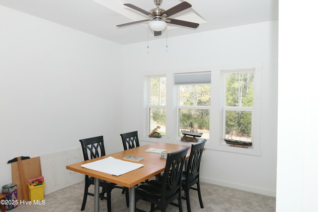 dining space with baseboards, ceiling fan, and light colored carpet