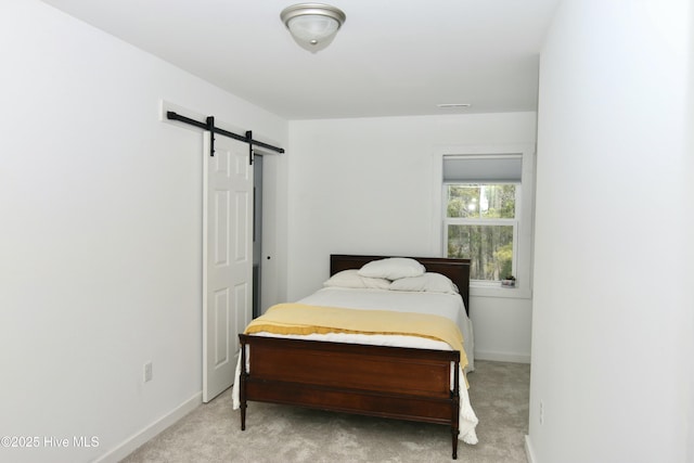 bedroom featuring baseboards, visible vents, a barn door, and carpet floors