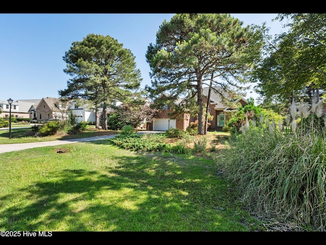 4404 Gauntlet Dr SE, Southport, NC 28461 - view of green lawn featuring a garage and driveway