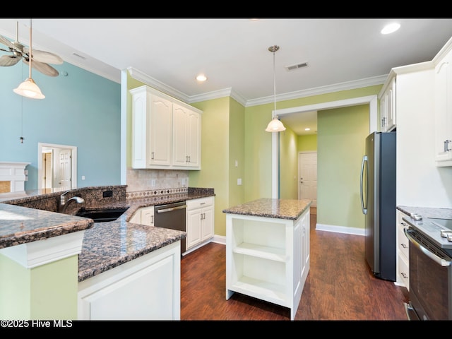 4404 Gauntlet Dr SE, Southport, NC 28461 - kitchen featuring stainless steel appliances, a sink, a ceiling fan, a center island, and dark wood-type flooring