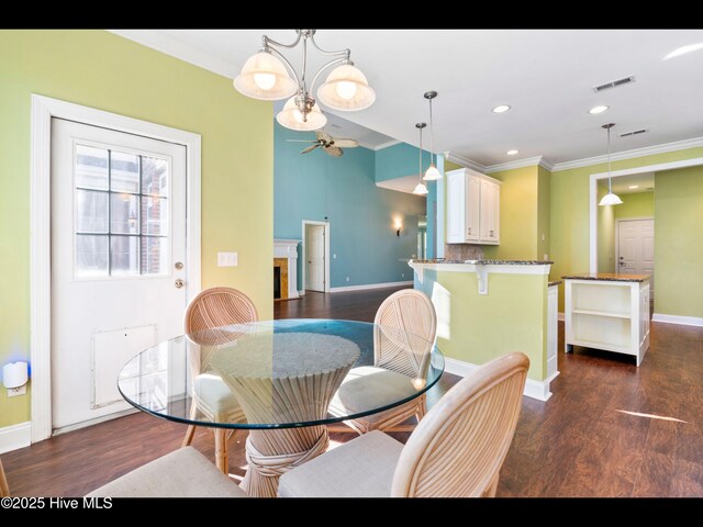 4404 Gauntlet Dr SE, Southport, NC 28461 - dining space featuring crown molding, dark wood finished floors, baseboards, ceiling fan, and recessed lighting
