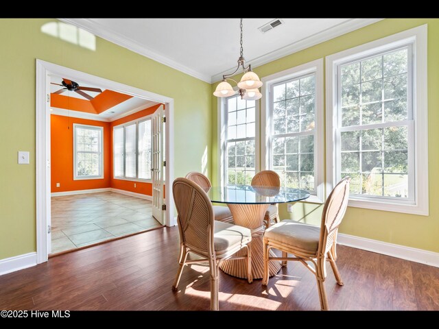 4404 Gauntlet Dr SE, Southport, NC 28461 - dining space featuring plenty of natural light, baseboards, crown molding, and wood finished floors