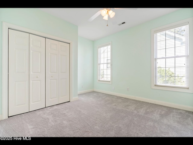 4404 Gauntlet Dr SE, Southport, NC 28461 - unfurnished bedroom with carpet, multiple windows, baseboards, and a closet