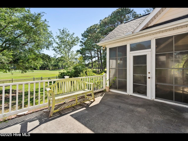4404 Gauntlet Dr SE, Southport, NC 28461 - view of patio / terrace with a sunroom and view of scattered trees