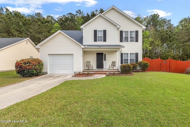traditional home featuring a front lawn, driveway, covered porch, fence, and an attached garage