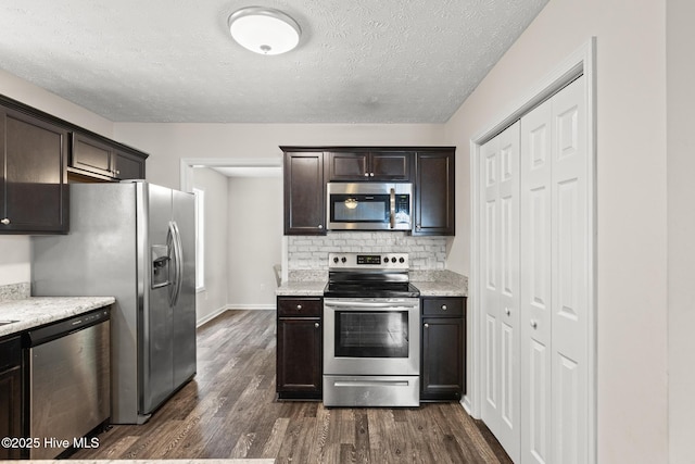 kitchen featuring tasteful backsplash, a textured ceiling, dark brown cabinetry, appliances with stainless steel finishes, and dark wood-style floors