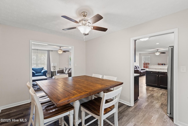 dining room with light wood-type flooring, a ceiling fan, and baseboards