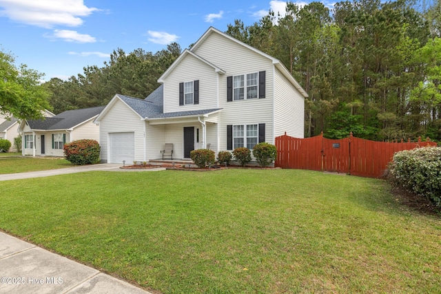 traditional-style home featuring a garage, driveway, a front lawn, and fence