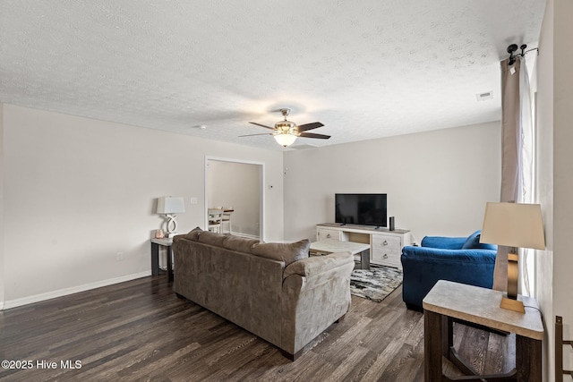 living area with a ceiling fan, dark wood-style flooring, a textured ceiling, and visible vents