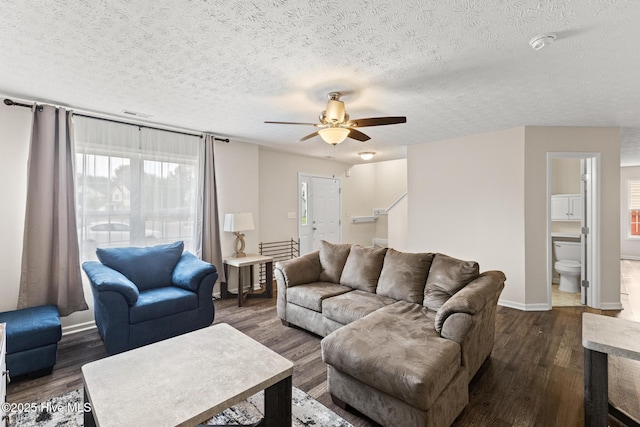 living room with baseboards, a textured ceiling, a ceiling fan, and dark wood-style floors
