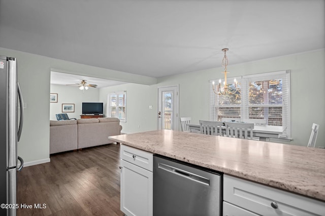 kitchen with white cabinets, light stone counters, dark wood-type flooring, and stainless steel appliances