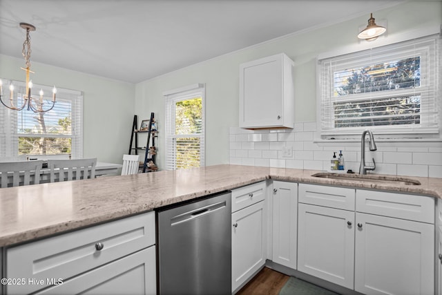 kitchen featuring a wealth of natural light, a sink, stainless steel dishwasher, and a notable chandelier