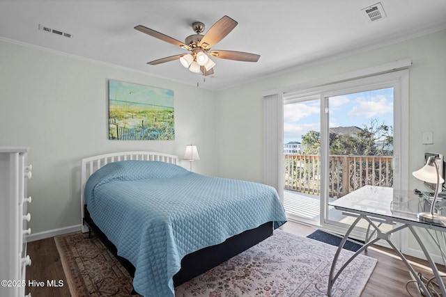 bedroom featuring wood finished floors, crown molding, access to outside, and visible vents